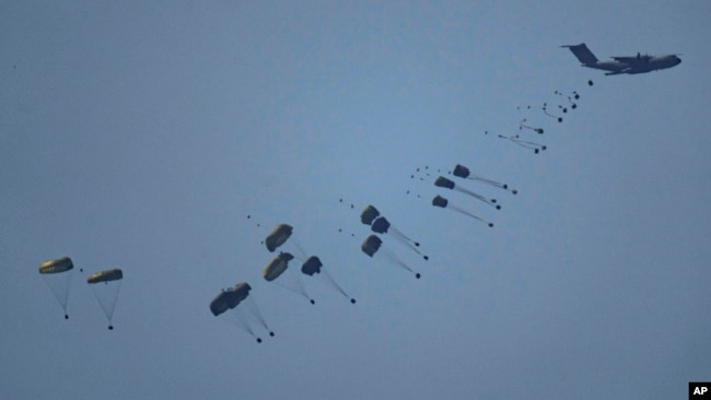 An aircraft airdrops humanitarian aid over Gaza the northern Gaza Strip, as seen from southern Israel, March 8, 2024.