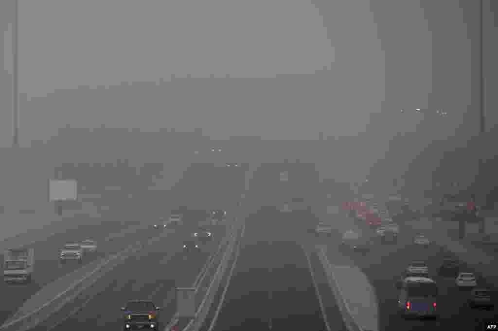 Vehicles drive during a heavy dust storm in Kuwait City.