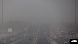 Vehicles drive during a heavy dust storm in Kuwait City, Aug. 26, 2024. 