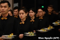 Waiters prepare to serve dishes at the Michelin Guide ceremony in Hanoi on June 6, 2023. Vietnam's booming food scene was awarded its first-ever Michelin stars Tuesday, with four restaurants selected by the dining guide. (Photo by Nhac Nguyen/AFP)