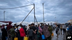 Palestinians displaced by the Israeli bombardment of the Gaza Strip queue for water at a U.N. displacement camp in the southern town of Khan Younis, Gaza Strip, Sunday on November 19, 2023. 