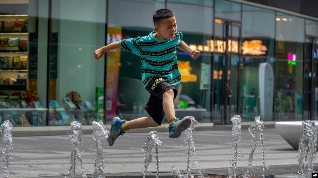 一个男孩在北京街头的喷水池玩水。（2023年7月1日）(photo:VOA)