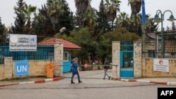 A Palestinian woman walks in front of the entrance of the UNRWA-run University College for Educational Science Ramallah city in the occupied West Bank on Jan. 29, 2024.