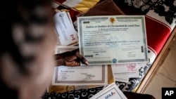 Salamba Ndiaye, a 28-year-old who tried to migrate to Europe twice, checks her school certificates at her house in Thiaroye-Sur-Mer, Senegal, Aug. 23, 2024.