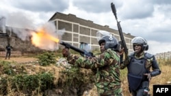Un officier de police kenyan tire une cartouche de gaz lacrymogène pour disperser des manifestants alors qu'ils se rassemblent pour manifester à Nairobi, au Kenya, le 12 juillet 2023.