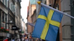 Bendera Swedia berkibar di luar sebuah toko dengan latar belakang kota tua Stockholm, Swedia, 14 Juli 2023. (Foto: REUTERS/Tom Little)