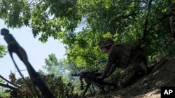 ৩৫ তম ব্রিগেডের একজন ইউক্রেনীয় মেরিন সেনা স্বয়ংক্রিয় গ্রেনেড লঞ্চার দিয়ে ইউক্রেনের আভদিভকার উপকণ্ঠে রুশ অবস্থানের দিকে গুলি চালায়। (১৯ জুন , ২০২৩)।