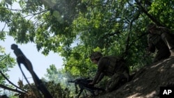 A Ukrainian marine of 35th brigade fires by automatic grenade launcher AGS-17 towards Russian positions on the outskirts of Avdiivka, Ukraine, June 19, 2023.