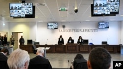 Officials listen as presiding judge Brigida Cavasino, center, reads the verdicts of a maxi-trial of hundreds of people accused of membership in Italy's 'Ndrangheta organized crime syndicate, in Lamezia Terme, southern Italy, Nov. 20, 2023. 