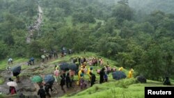 Personel Pasukan Tanggap Bencana Nasional (NDRF) dan sukarelawan lainnya mendaki gunung untuk mencapai lokasi tanah longsor di sebuah desa di Raigad, di negara bagian barat Maharashtra, India 20 Juli 2023. (REUTERS/Francis Mascarenhas)