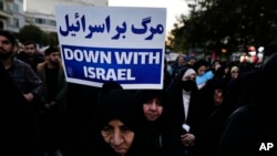 An Iranian demonstrator holds up an anti-Israeli placard in a pro-Palestinian rally at Islamic Revolution Square in Tehran, Iran, Nov. 18, 2023.