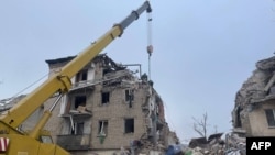 This handout picture taken and released Nov. 16, 2023, by Ukrainian Emergency Service shows rescuers clearing debris of a residential building damaged after a Russian strike in Selydove, Donetsk region.