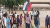 A man holds a Russian flag as Nigerians protest in the streets during anti-government demonstrations against bad governance and economic hardship, in Kaduna state, Aug. 5, 2024. 