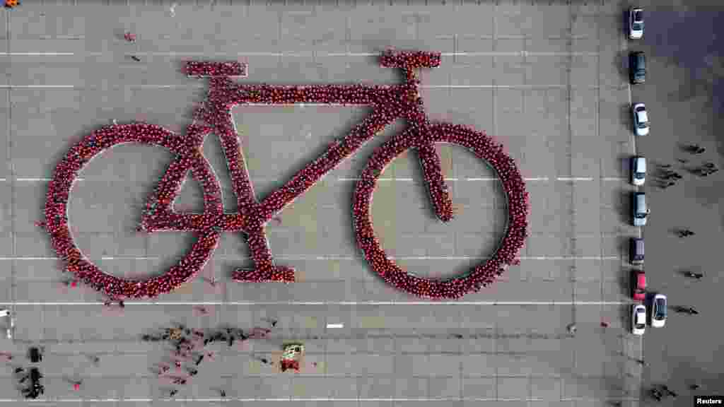 Local residents make a formation in the shape of a bicycle in an attempt to do the world's largest bicycle as part of a Bicycle Festival, in Santiago, Chile, May 27, 2023. 