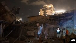 People look at the damage from a rocket fired from the Gaza Strip in Tel Aviv, Israel, Oct. 7, 2023. 