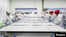 资料照：巴西工人在位于坎皮纳斯的中国太阳能设备制造商比亚迪工厂制造太阳能电池板的生产线上工作。（2020年2月13日）