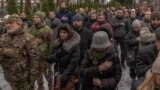 Civilians and Ukrainian servicemen attend the funeral service of Ukrainian serviceman Sergiy Pavlichenko, who was killed fighting Russian troops in the Zaporizhzhia region, at a cemetery in Kyiv, Ukraine, Nov. 29, 2023.