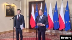 FILE - Poland's Prime Minister Donald Tusk and Finance Minister Andrzej Domanski attend a press conference about the budget at Prime Minister Chancellery in Warsaw, Poland, Dec. 19, 2023. 