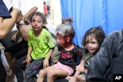 Palestinian children wounded in Israel strikes are brought to Shifa Hospital in Gaza City, Oct. 11, 2023.