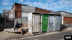 FILE - A man is seen sitting on a pavement in the Khayelitsha, near Cape Town, on April 21, 2022.