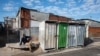 FILE - A man is sits on the pavement in Khayelitsha township, near Cape Town, April 21, 2022.