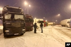 FILE - Ukrainian truck drivers wait to cross from Poland back into Ukraine in Korczowa, Poland, Dec. 7, 2023. A Ukrainian driver who got sick at the Korczowa-Krakovets crossing — one of four crossing points blocked by protesters— died while being taken to a hospital.
