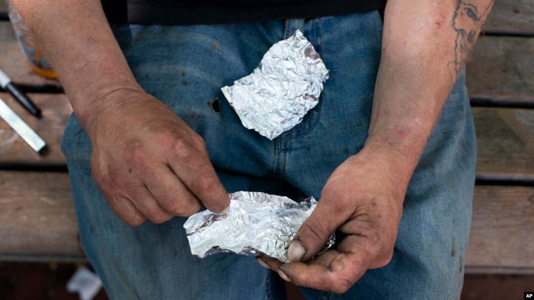 Seorang pria bersiap untuk merokok fentanil di sebuah bangku taman di Portland, Oregon, pada 18 Mei 2023. (Foto: Beth Nakamura/The Oregonian via AP)