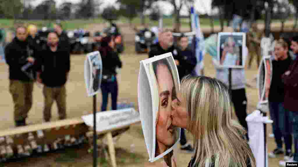 A woman kisses a picture of Mercedes Oria Amar, who was killed at the site of the Nova festival during the Oct. 7 attack by Hamas gunmen, in Reim, in southern Israel.