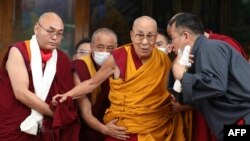 Pemimpin spiritual Tibet Dalai Lama dibantu berjalan saat ia tiba di acara peringatan hari ulang tahunnya yang ke-88 di Dharamsala, India, pada 6 Juli 2023. (Foto: AFP/Sanjay Baid)