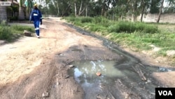 A man walks past flowing sewage in Harare, Zimbabwe, on Jan. 17, 2024. (Columbus Mavhunga/VOA)