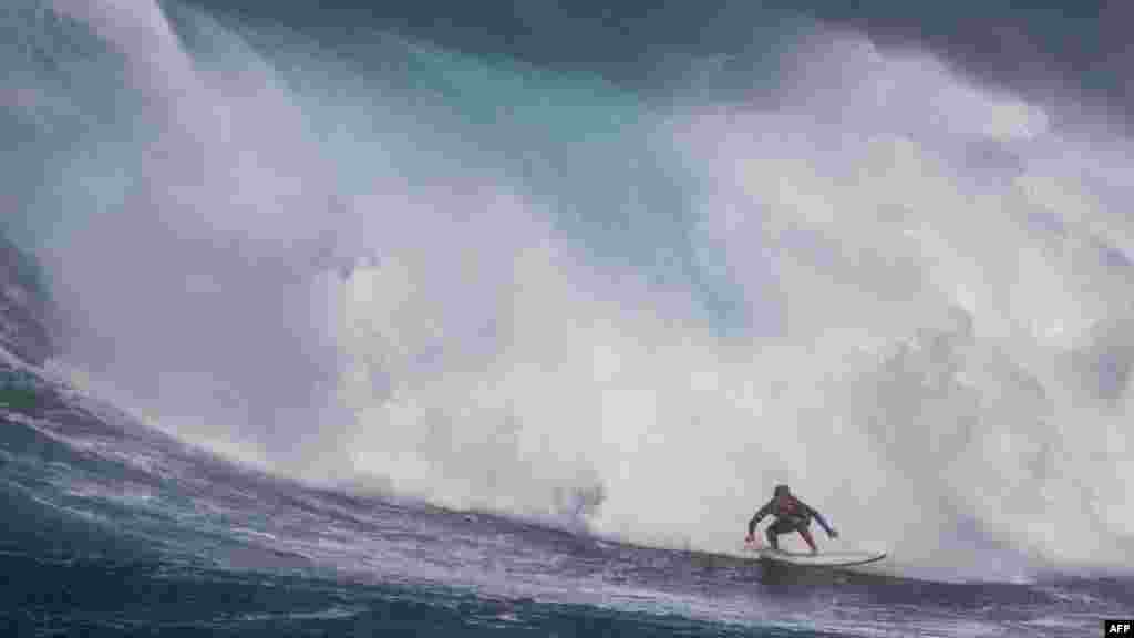 Peselancar Hawaii Steve Roberson berusaha mengarungi ombak saat gelombang besar menghantam tempat selancar Pe&#39;ahi, yang dikenal sebagai Jaws, di pantai utara pulau Maui, Hawaii. (AFP)