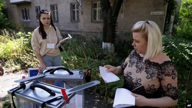 Punonjëset zgjedhore duke mbledhur votat derë më derë në Donetsk (6 shtator 2023)