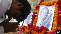 A student pays tribute to legendary Indian sitar player Ravi Shankar at the Bengali Tola Inter College, where Shankar had studied in Varanasi, India, Dec. 12, 2012. 