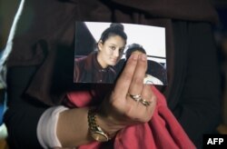 FILE - Renu Begum, eldest sister of missing sister of missing British girl Shamima Begum, holds a picture of her sister while being interviewed by the media in central London, Feb. 22, 2015.