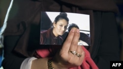 FILE - Renu Begum, eldest sister of missing sister of missing British girl Shamima Begum, holds a picture of her sister while being interviewed by the media in central London, Feb. 22, 2015.