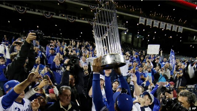 Jarrod Dyson de los Reales de Kansas levanta el trofeo de la Serie Mundial al final del quinto juego del torneo de la Liga Mayor de Béisbol, contra los Mets de New York. Nov. 2, 2015.