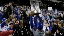 Kansas City Royals' Jarrod Dyson holds the World Series trophy after Game 5 of the Major League Baseball World Series against the New York Mets Monday, Nov. 2, 2015.