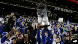 Jarrod Dyson de los Reales de Kansas levanta el trofeo de la Serie Mundial al final del quinto juego del torneo de la Liga Mayor de Béisbol, contra los Mets de New York. Nov. 2, 2015.