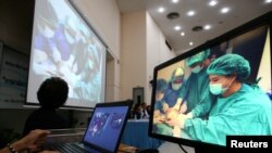 Layar menunjukkan para dokter hewan Thailand sedang mengoperasi Omsin, penyu hijau betina berusia 25 tahun, untuk mengambil koin-koin dari perutnya, dalam konferensi pers di Chulalongkorn University di Bangkok, Thailand (6/3). (Reuters/Athit Perawongmetha)