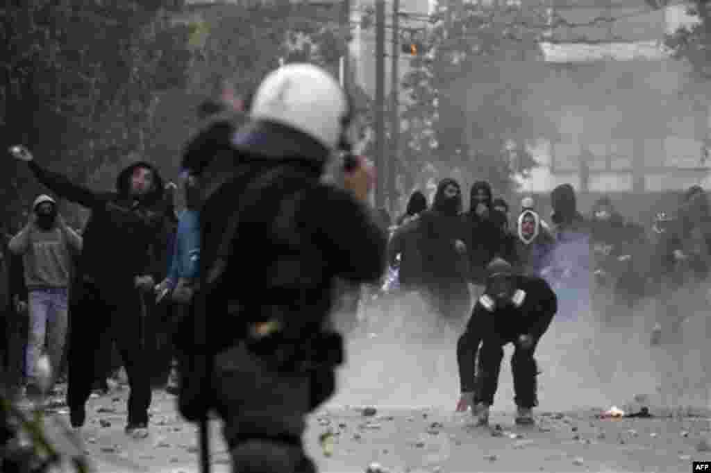 Protesters throw stones at riot police during rioting in central Athens, Thursday, Oct. 20, 2011. Greek anger over new austerity measures and layoffs erupted into violence Wednesday, as demonstrators hurled chunks of marble and gasoline bombs and riot pol