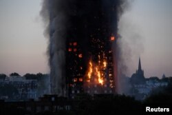 Flames and smoke billow as firefighters deal with a serious fire in a tower block at Latimer Road in West London, Britain, June 14, 2017.