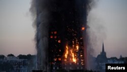 Flames and smoke billow as firefighters deal with a serious fire in a tower block at Latimer Road in West London, Britain, June 14, 2017.