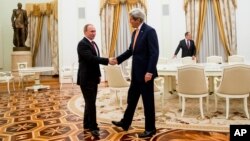 Ngoại trưởng John Kerry bắt tay với Tổng thống Vladimir Putin sau buổi họp tại điện Kremlin ở Moscow, Nga, ngày 24/3/2016.