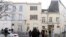 Reporters stand in front of an apartment (C) in the Brussels district of Forest where a gunman was shot dead by Belgian police on Tuesday after a raid on the apartment linked to investigations into November's Islamist attacks in Paris, March 16, 2016. 