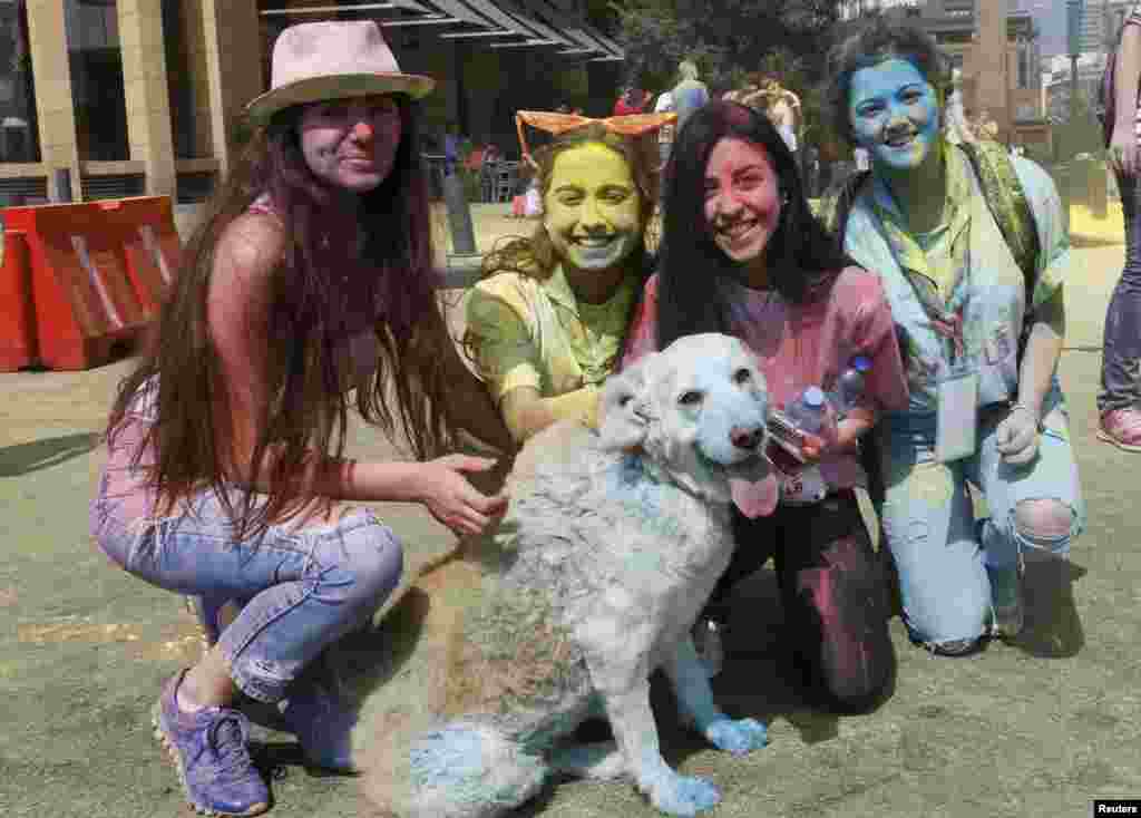 Orang-orang berpose dengan seekor anjing yang diselimuti bedak warna-warni dalam lomba lari warna-warni pertama yang disebut &quot;Alwan LB&quot; di Beirut.