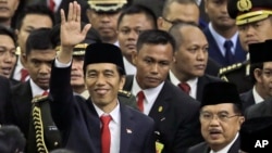 印尼總統佐科威星期一﹐在議會大廈舉行的就職儀式上與副總統在一起，向人們招手示意。