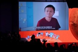 FILE - A screen shows footage of Alibaba Group co-founder Jack Ma during the Alibaba Group's listing ceremony at the Hong Kong Stock Exchange (HKEX) in Hong Kong, Nov. 26, 2019.