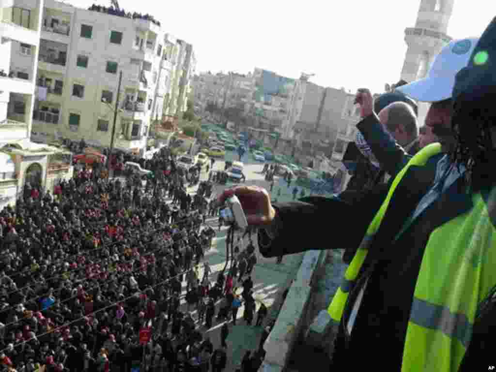 Arab League observers take photos of anti-government protesters on the streets in Adlb, Syria on December 30, 2011. (Reuters)