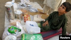 Adnan, 8, whose family fled from the military offensive against Pakistani militants in North Waziristan, sells ration packs that were collected by his family from a distribution point for internally displaced persons in Bannu,Khyber-Pakhtunkhwa province, 