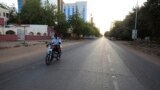 FILE - A lone motorcyclist is seen on an otherwise empty street in Khartoum , Sudan, March 24, 2020, as the Sudanese government ordered a nighttime curfew to prevent the spread of the coronavirus.